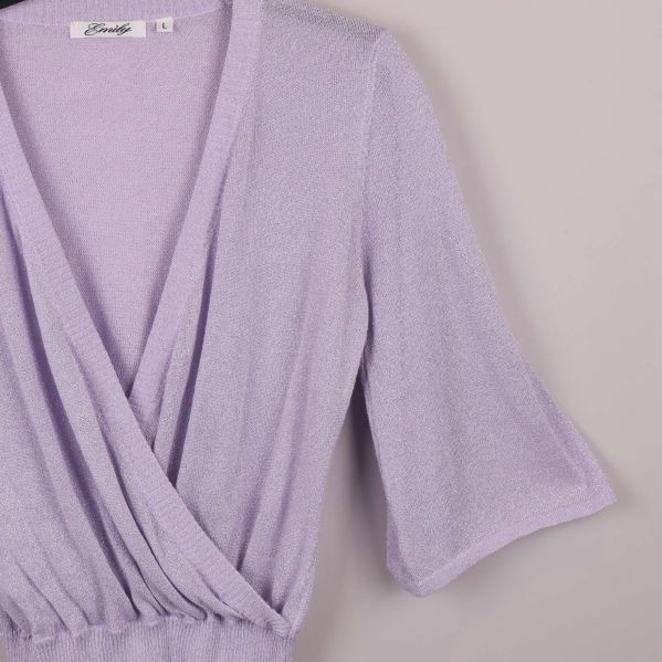 Närbild på glittrigt tyg och omlott-skärning vid ärmen