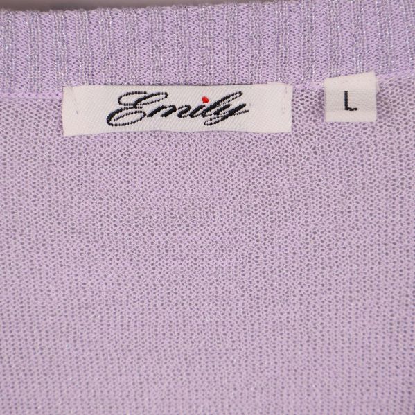 Etikett med texten Emily och storlek L på lila topp