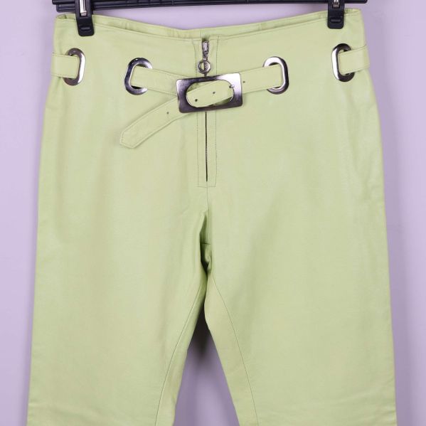 Närbild på midja och bälte på ljusgröna läderbyxor