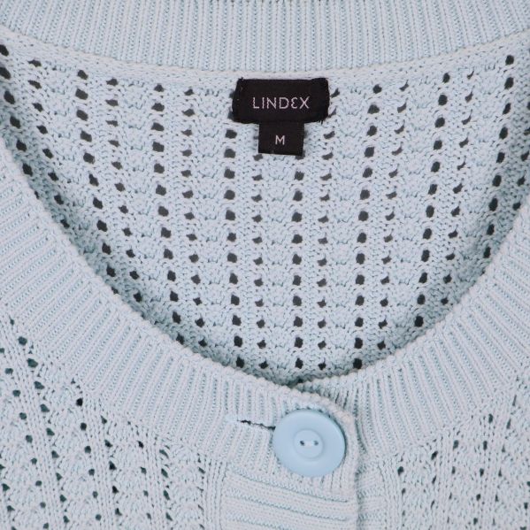 Närbild på Lindex-etikett och halsringning i ljusblå kofta