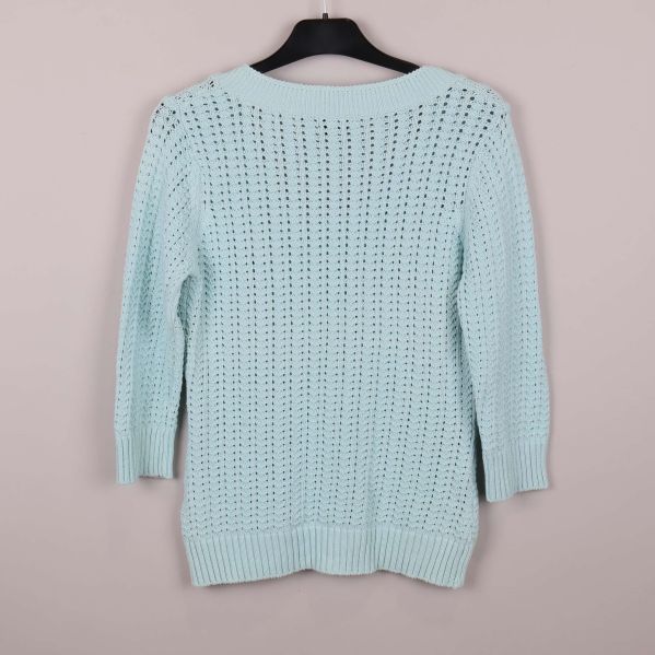 Baksida på ljusblå stickad kofta med hålmönster