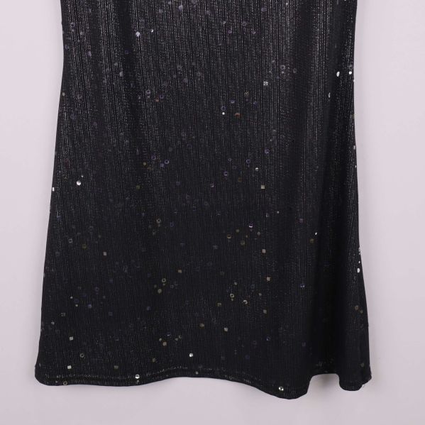 Nedre delen av svart klänning med glittriga paljetter