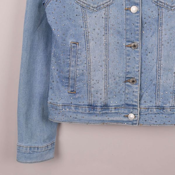 Närbild på nedre delen av jeansjacka och strassdekorationer