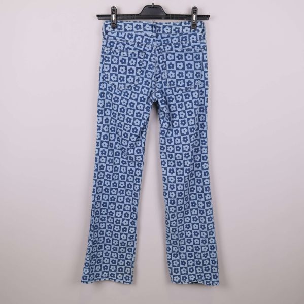 Baksidan av jeans med blommönster visas på galge