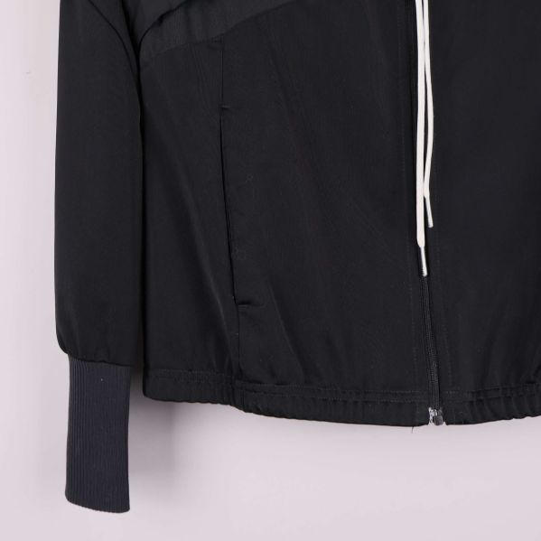 Närbild på nederdel och dragsko vid jackans midja