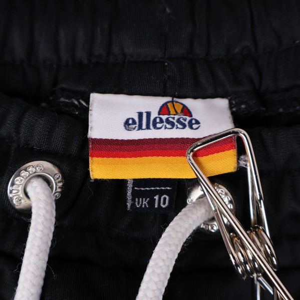 Närbild på ellesse-logotyp på etikett och snörning i midjan
