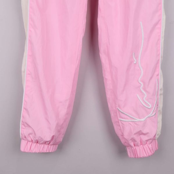 Detaljbild på nedre del med broderad logga vid benet