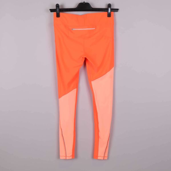 Orange träningstights med ljusare paneler bakifrån