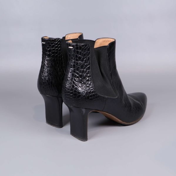 Bakre och sidan av boots med markerad klack och krokopräglad yta