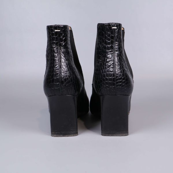 Bakifrån av boots med kraftig klack och krokoprägling