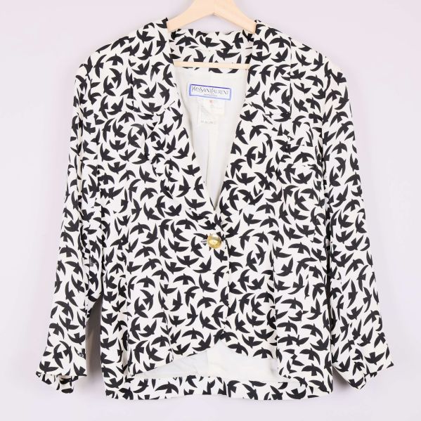 Framsida av svartvit kavaj med fågelmönster och guldknapp