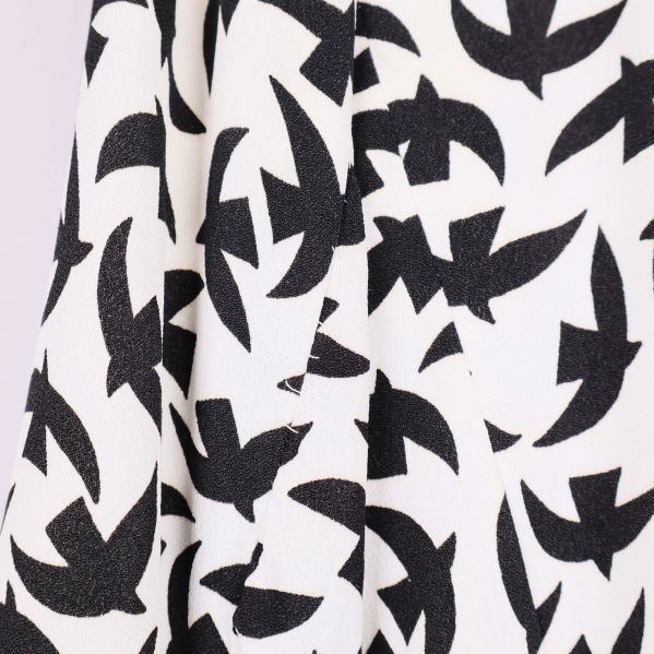Närbild av tyg med svart på vitt fågelmönster