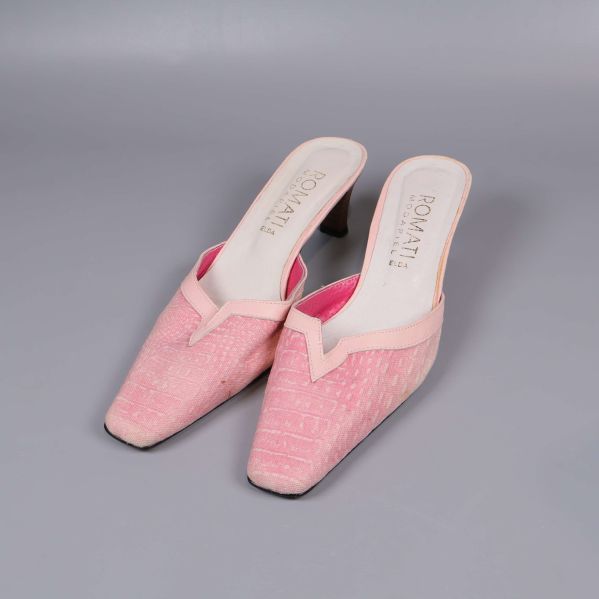 Rosa mules med klack i frontvy på grå bakgrund