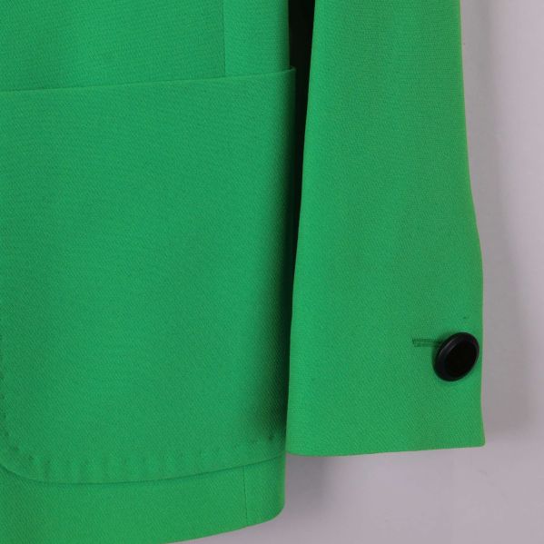 Närbild på kavajärm med svart knapp