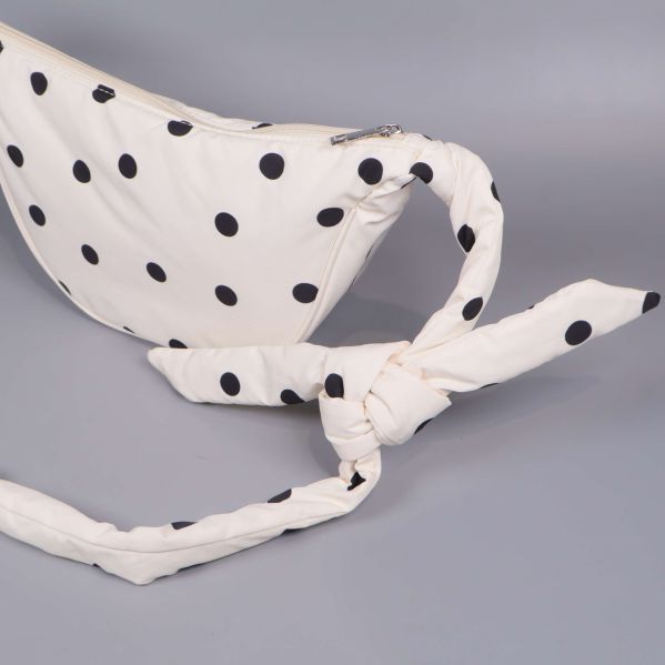 Närbild på knytband på prickig magväska