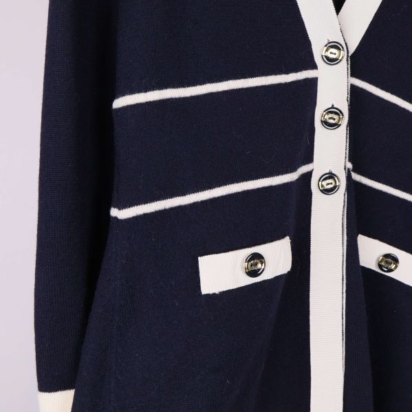 Närbild på fickor och dekorativa knappar på koftan