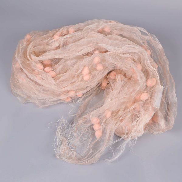 Sjal med många små pompoms, fotograferad bakifrån