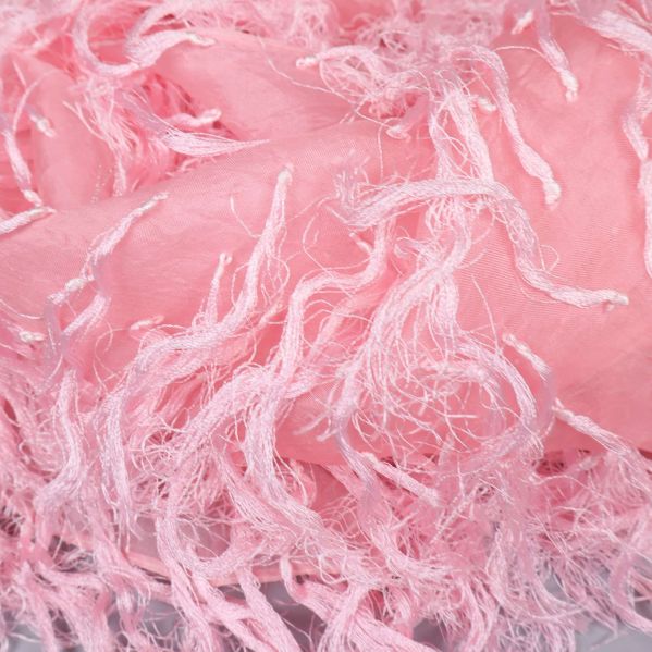 Närbild på rosa sjalens fransiga textur och mjuka material