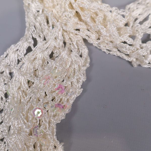 Närbild på sjalens virkning och iriserande paljetter