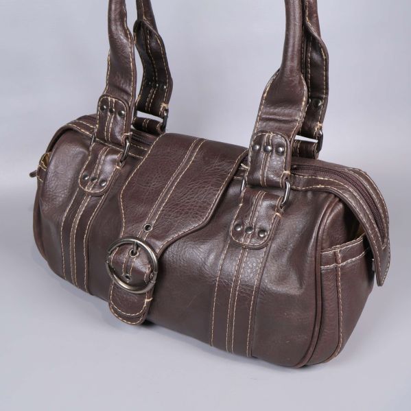 Närbild på axelväska och dess detaljerade metallspänne