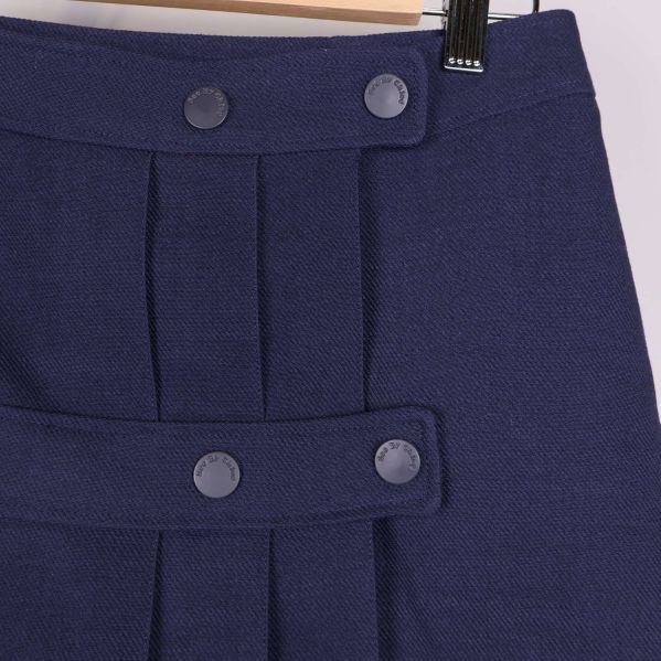 Detalj på knappar och veck framtill på kjolen