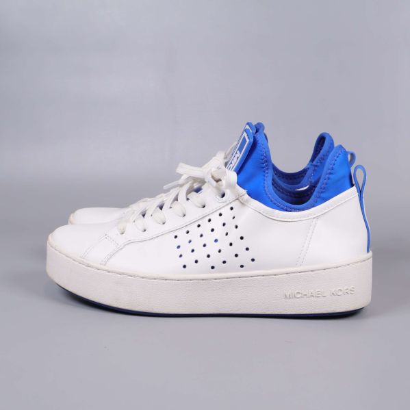 Vita sneakers från Michael Kors fotograferade från sidan