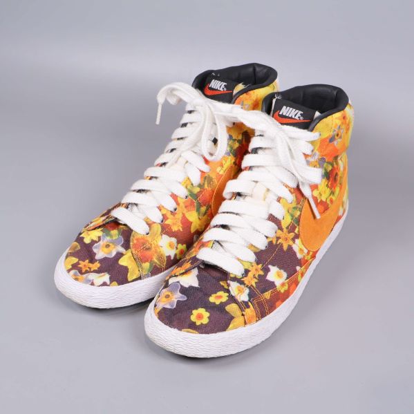 Nike sneakers visade framifrån med vita snören och blommigt tyg