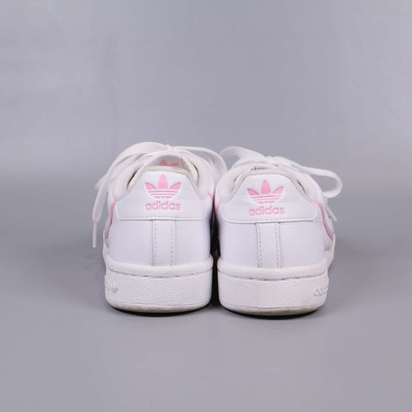 Baksida av vita sneakers med rosa adidas-logga