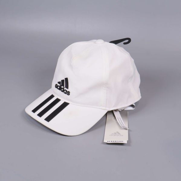 Vit adidaskeps med svarta detaljer och etikett synlig