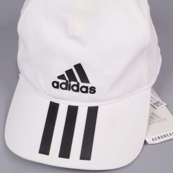 Närbild på kepsens svarta adidaslogga och ränder