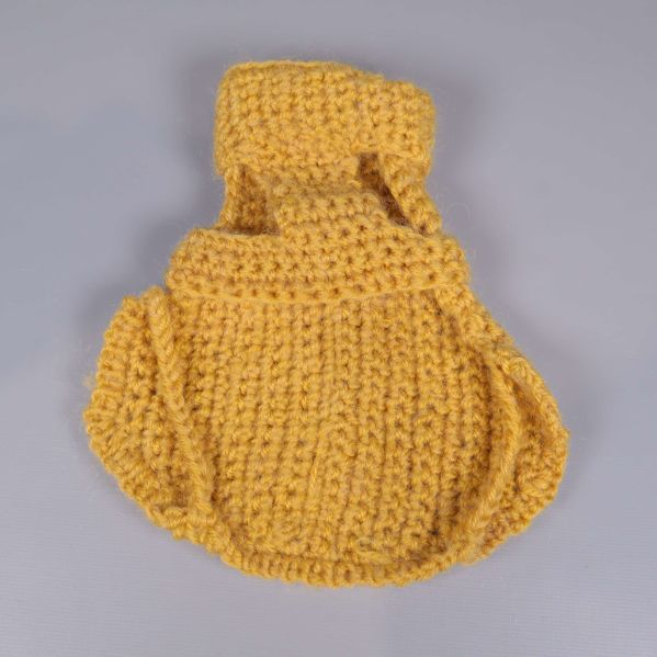 Baksidan av stickad gul hundtröja på grå bakgrund