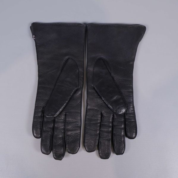 Handskar i svart lammskinn visade med baksidan uppåt