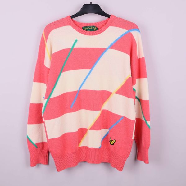 Randig tröja i aprikos och gräddvit med färglada streck på galge