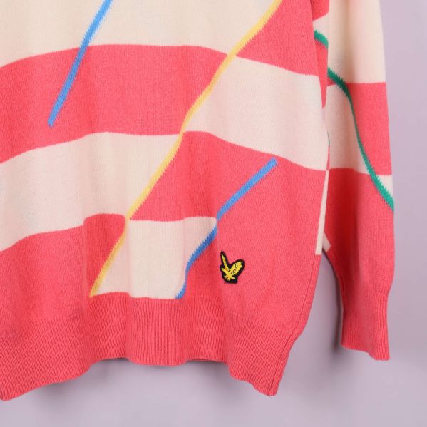 Nedre del av tröja med logotyp broderad vid fållen och färgglada linjer