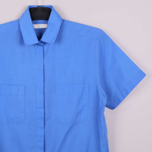 Närbild på blå skjorta med krage och fickor