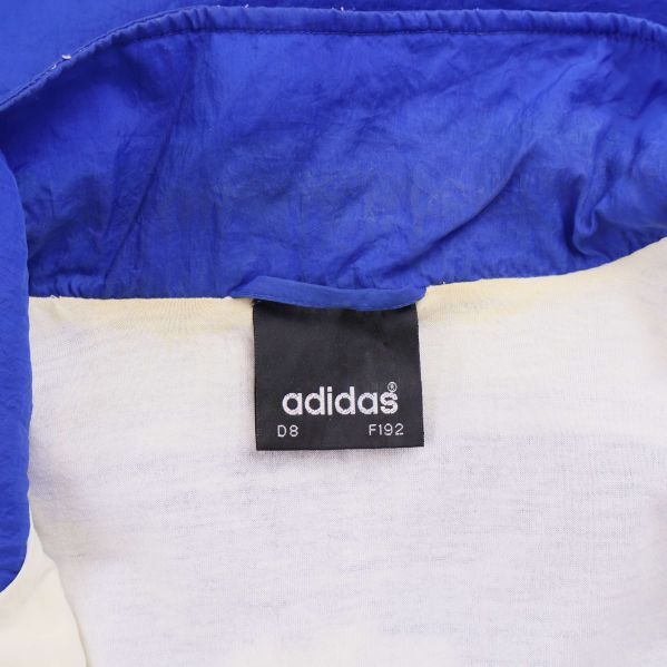 Etikett med Adidas logotyp och storleksangivelser inuti jackan