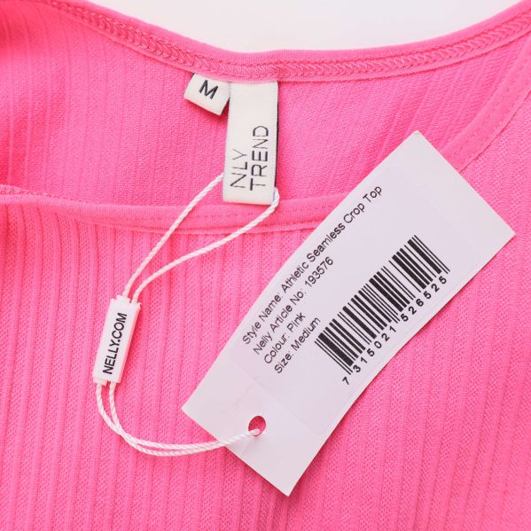 Närbild på etikett och materialinformation inuti rosa crop top