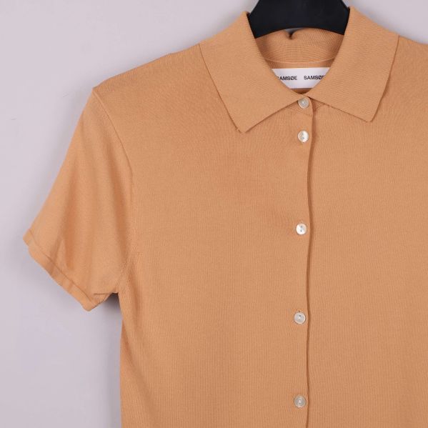 Närbild på krage och axel av stickad skjorttröja