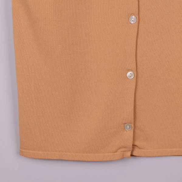 Närbild på nederkant och knappslå av skjorttröjan