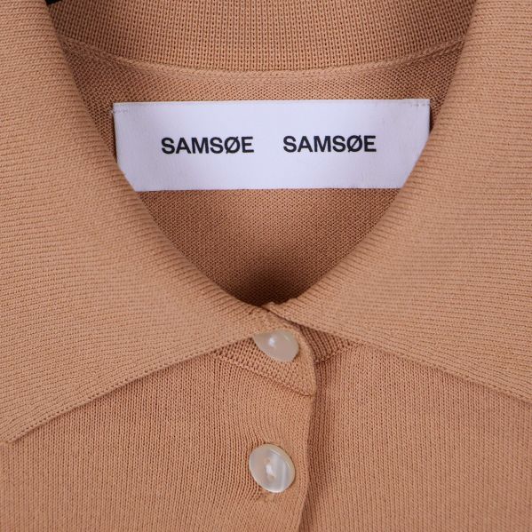 Närbild på etikett med Samsøe Samsøe-logotyp vid kragen