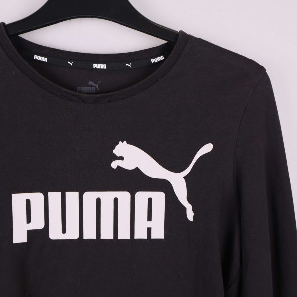 Närbild på vit PUMA-logga framtill på crop top