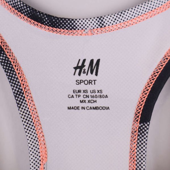 Närbild av H&M Sport-logotyp och storleksinformation i linnet