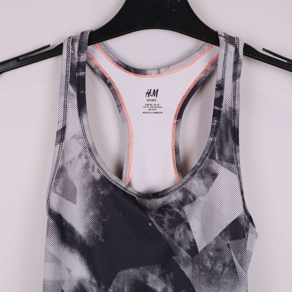 Detalj fram på linnet med orange sömmar och grafiskt tryck