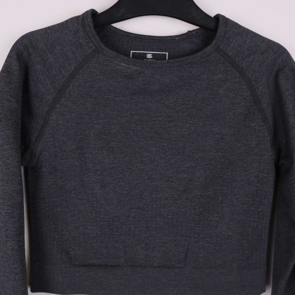 Närbild på cropad tröja med rund hals och sömdetaljer