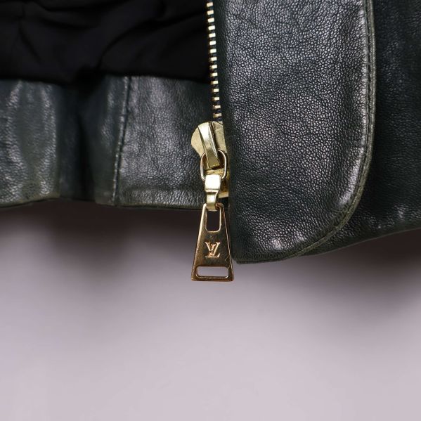 Detaljerad bild på guld dragkedja med LV-logo