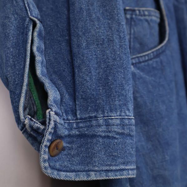 Närbild på ärmslut med knapp och söm