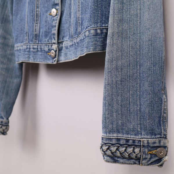 Närbild på ärmslut med flätad denimdetalj