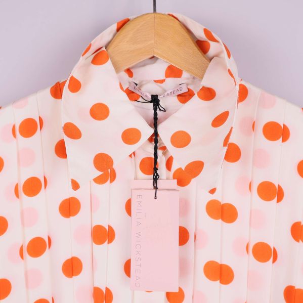 Närbild på krage och etikett på prickig klänning