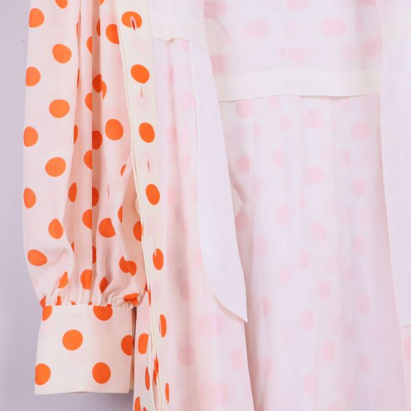 Insida av prickig klänning samt foder visas i närbild