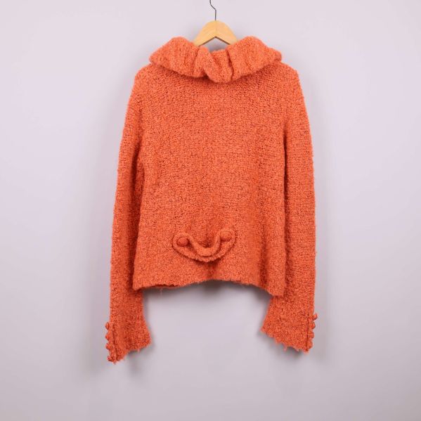 Baksidan av orange stickad kofta med krage
